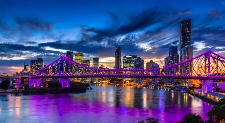 Is Brisbane Worth Visiting? Of course, this photo of Brisbane at night showing the iconic Story Bridge lit up in the background