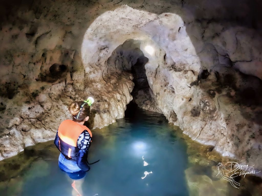 A woman inside Sambulawan Cave in Siquijor with turquoise waters.
